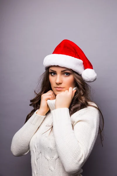 Beautiful happy young Caucasian brunette woman wearing Santa Claus beanie hat .