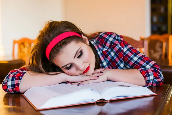 Müdes Studentenmädchen schläft auf den Büchern in der Bibliothek — Stockfoto