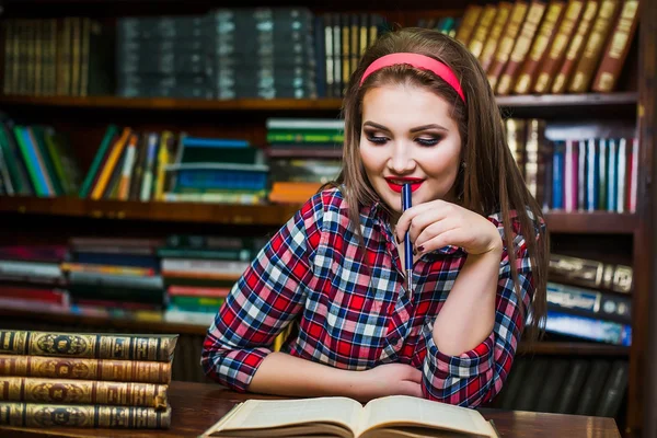 Chica inteligente estudiante pelo cola de caballo sentado en la biblioteca con libros. De interior — Foto de Stock