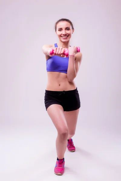 Mujer atlética deportiva activa con pesas bombeando músculos bíceps — Foto de Stock