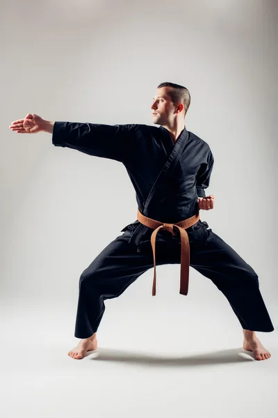 Young male with orange belt karate fighter training.