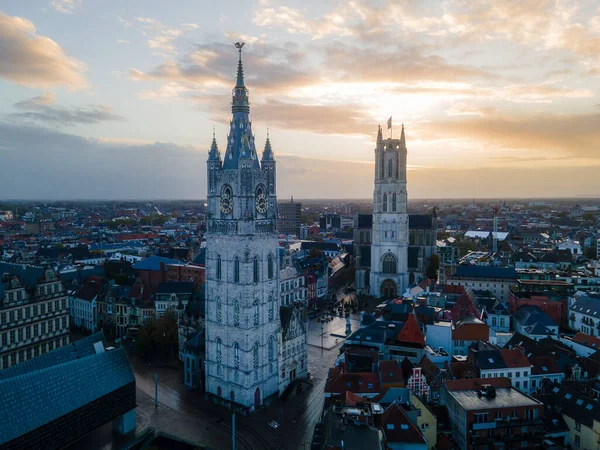 Smooth aerial movement over Ghent old town with towers, canals, and stone architecture.