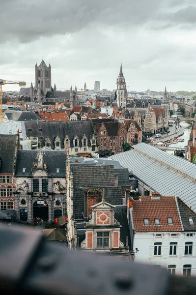 Wide cityscape from Gravensteen Castle featuring the rooftops, churches, and canals of Ghent.