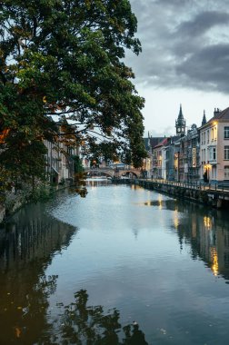 Ghent, Belgium - October 5, 2025 - Classic canal scene with an arched stone bridge and old Belgian houses in Ghent.