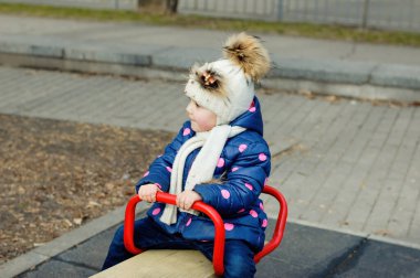 Sevimli Çocuk Mahalle Oyun Bahçesinde Güzel Zamanlar ve Maceralar Geçiriyor. Parkta oynayan sağlıklı, mutlu bir bebek. Çocuklar için şık kıyafetler.