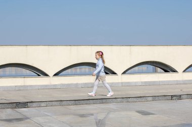 Sevimli Çocuk Mahalle Oyun Bahçesinde Güzel Zamanlar ve Maceralar Geçiriyor. Güvercinlerle koşan sağlıklı, mutlu bir bebek. Çocuklar için şık kıyafetler.