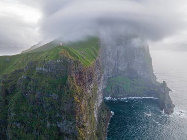 Danimarka 'nın Faroe Adaları, Kalsoy adasının yeşil tepelerindeki Kallur deniz fenerinin hava manzarası. Manzara fotoğrafçılığı. Yüksek kalite fotoğraf