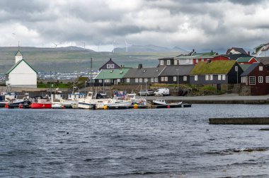 Nolsoy, Faroe Adaları - 5 Ağustos 2025: Nolsoy, Faroe Adaları manzaralı deniz kenarındaki renkli balıkçıların evleri, geleneksel İskandinav cazibesini ve kıyı yaşam tarzını yansıtıyor.