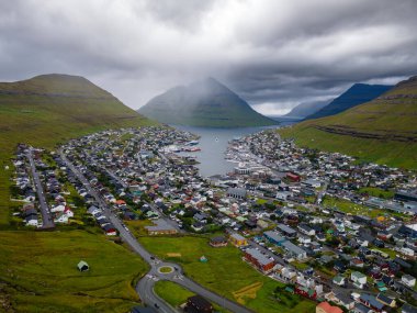 Faroe Adaları, Danimarka, Kuzey Atlantik 'teki fiyort ve dağların arasına yerleşmiş Klaksvik şehrinin nefes kesici panoramik manzarası..