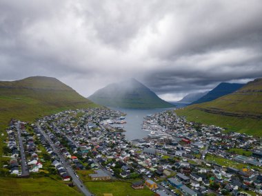 Faroe Adaları, Danimarka, Kuzey Atlantik 'teki fiyort ve dağların arasına yerleşmiş Klaksvik şehrinin nefes kesici panoramik manzarası..