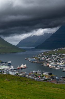 Faroe Adaları, Danimarka, Kuzey Atlantik 'teki fiyort ve dağların arasına yerleşmiş Klaksvik şehrinin nefes kesici panoramik manzarası..