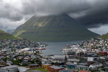 Faroe Adaları, Danimarka, Kuzey Atlantik 'teki fiyort ve dağların arasına yerleşmiş Klaksvik şehrinin nefes kesici panoramik manzarası..