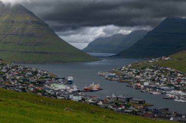 Faroe Adaları, Danimarka, Kuzey Atlantik 'teki fiyort ve dağların arasına yerleşmiş Klaksvik şehrinin nefes kesici panoramik manzarası..