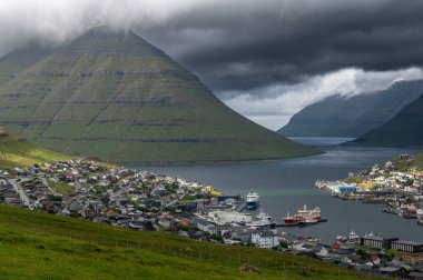 Faroe Adaları, Danimarka, Kuzey Atlantik 'teki fiyort ve dağların arasına yerleşmiş Klaksvik şehrinin nefes kesici panoramik manzarası..