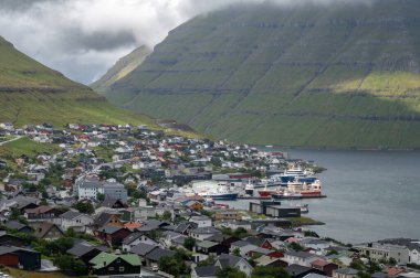 Faroe Adaları, Danimarka, Kuzey Atlantik 'teki fiyort ve dağların arasına yerleşmiş Klaksvik şehrinin nefes kesici panoramik manzarası..