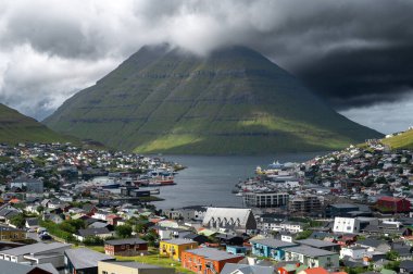 Faroe Adaları, Danimarka, Kuzey Atlantik 'teki fiyort ve dağların arasına yerleşmiş Klaksvik şehrinin nefes kesici panoramik manzarası..