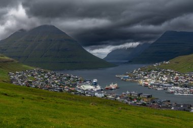 Faroe Adaları, Danimarka, Kuzey Atlantik 'teki fiyort ve dağların arasına yerleşmiş Klaksvik şehrinin nefes kesici panoramik manzarası..
