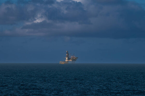 Offshore oil platform, drilling rig, and supply boat at twilight. High quality photo