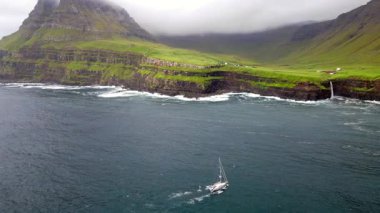 Dramatik Mulafossur şelalesi Gasadalur köyü ve arka planda kayalıklarla okyanusa dökülüyor..