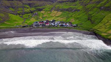 Streymoy 'un kuzey kıyısında etkileyici bir köy olan Tjornuvik' in manzarası dramatik dağlar ve okyanuslarla çevrili..