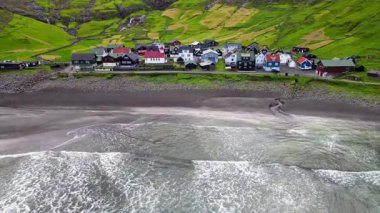 Streymoy 'un kuzey kıyısında etkileyici bir köy olan Tjornuvik' in manzarası dramatik dağlar ve okyanuslarla çevrili..