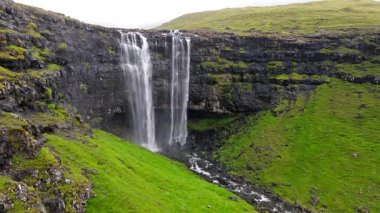 Muhteşem Fossa şelalesi, Faroe Adaları 'nın en yüksek şelalesi, Kuzey Atlantik' in engebeli kayalıklarından aşağı dökülüyor..