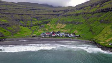 Streymoy 'un kuzey kıyısında etkileyici bir köy olan Tjornuvik' in manzarası dramatik dağlar ve okyanuslarla çevrili..