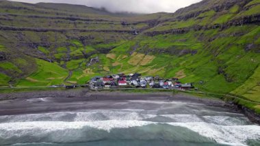 Streymoy 'un kuzey kıyısında etkileyici bir köy olan Tjornuvik' in manzarası dramatik dağlar ve okyanuslarla çevrili..