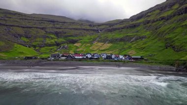 Streymoy 'un kuzey kıyısında etkileyici bir köy olan Tjornuvik' in manzarası dramatik dağlar ve okyanuslarla çevrili..