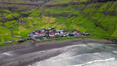 Streymoy 'un kuzey kıyısında etkileyici bir köy olan Tjornuvik' in manzarası dramatik dağlar ve okyanuslarla çevrili..