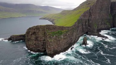Danimarka 'nın Faroe Adası kıyı şeridi Faroe Adası, Avrupa' da sabahın erken saatlerinde yapılan yürüyüş sırasında Tindholmur adaları ile ünlü Drangarnir uçurumunun yakın plan çekimi. Yüksek kalite fotoğraf