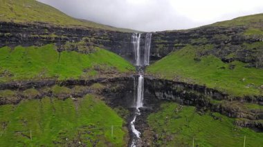Muhteşem Fossa şelalesi, Faroe Adaları 'nın en yüksek şelalesi, Kuzey Atlantik' in engebeli kayalıklarından aşağı dökülüyor..