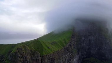 Danimarka 'nın Faroe Adaları, Kalsoy adasının yeşil tepelerindeki Kallur deniz fenerinin hava manzarası. Manzara fotoğrafçılığı. Yüksek kalite fotoğraf