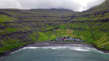Streymoy 'un kuzey kıyısında etkileyici bir köy olan Tjornuvik' in manzarası dramatik dağlar ve okyanuslarla çevrili..
