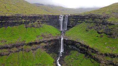 Muhteşem Fossa şelalesi, Faroe Adaları 'nın en yüksek şelalesi, Kuzey Atlantik' in engebeli kayalıklarından aşağı dökülüyor..