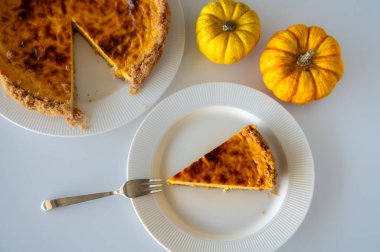 Kremalı ev yapımı balkabaklı cheesecake dilimine yakın plan. Sonbahar aromalı, pürüzsüz bir tadı ve baharatlı aroması var..