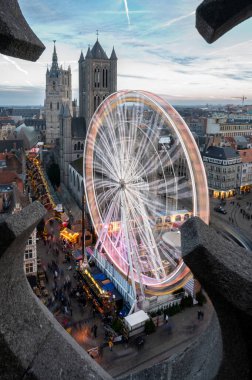 Ghent Noel Pazarı 'nın hava manzarası tatil ışıklarıyla, rahat tezgahlarla ve tarihi şehir merkezinde canlı kalabalıklarla parlıyor..