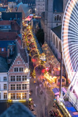 Gent, Belçika - 5 Aralık 2025: Gent Noel Pazarı 'nın bayram ışıkları, samimi tezgahlar ve tarihi şehir merkezinde canlı kalabalıklarla parıldayan hava manzarası.