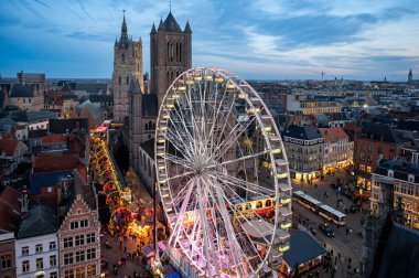 Gent, Belçika - 5 Aralık 2025: Gent Noel Pazarı 'nın bayram ışıkları, samimi tezgahlar ve tarihi şehir merkezinde canlı kalabalıklarla parıldayan hava manzarası.