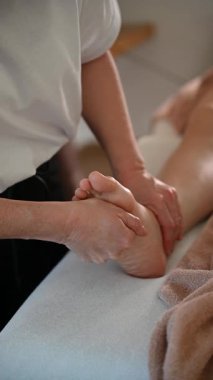 Rahatlatıcı bir ortamda profesyonel masajdan hoşlanan genç bir kadının olduğu huzurlu bir spa sahnesi..