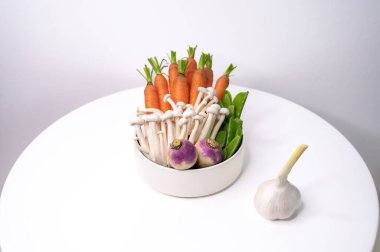 Beyaz bir tabakta servis edilen havuç, mantar, yeşil fasulye ve şalgam çeşitleri. Temiz, sağlıklı, organik çiftçiler gıda konsepti.