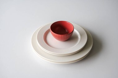 Beyaz tabaklar ve beyaz bir masada kırmızı bir kase. Yüksek kalite fotoğraf