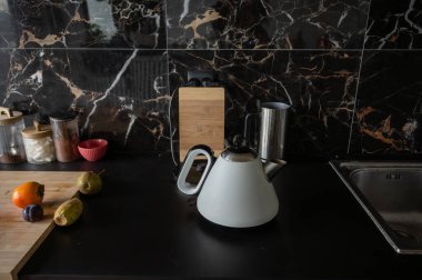 Siyah mutfakta beyaz elektrikli çaydanlık. Yüksek kalite fotoğraf