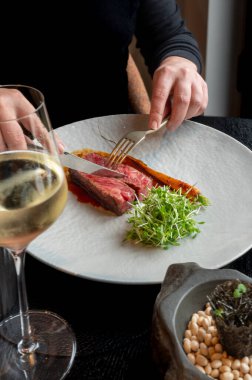 Mükemmel pişmiş çizgili biftek, yumuşak dokulu, gurme yemek deneyimi için karanlık bir yüzeyde sunuluyor..