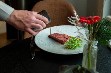 Mükemmel pişirilmiş çizgili bifteğe yakın plan koyu arkaplanda yumuşak, sulu bir doku..