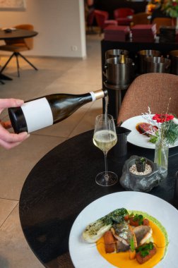 Lüks bir restoran ortamında servis edilen zarif bir balık yemeğinin profesyonel sunumu..