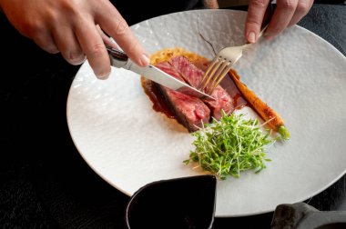 Sulu, orta pişmiş bir bifteğin yakın çekimi koyu bir arka planda, güzel yemek görselleri için ideal..