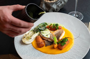 Sofistike bir restoranda sofistike bir balık yemeği servis ediliyor, güzel yemek yemekleri vurgulanıyor..