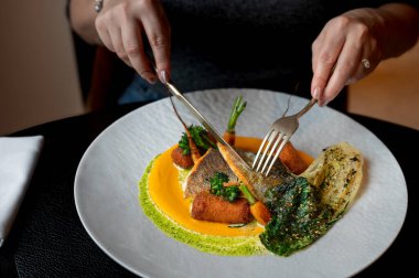 Yaratıcılığı ve lüks mutfağı vurgulayan altın garnitürlü bir balık tabağının yakın plan görüntüsü.