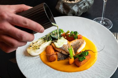 Lüks bir yemek ortamında sunulan, sanatsal garnitürlü kaliteli balık tabağı..